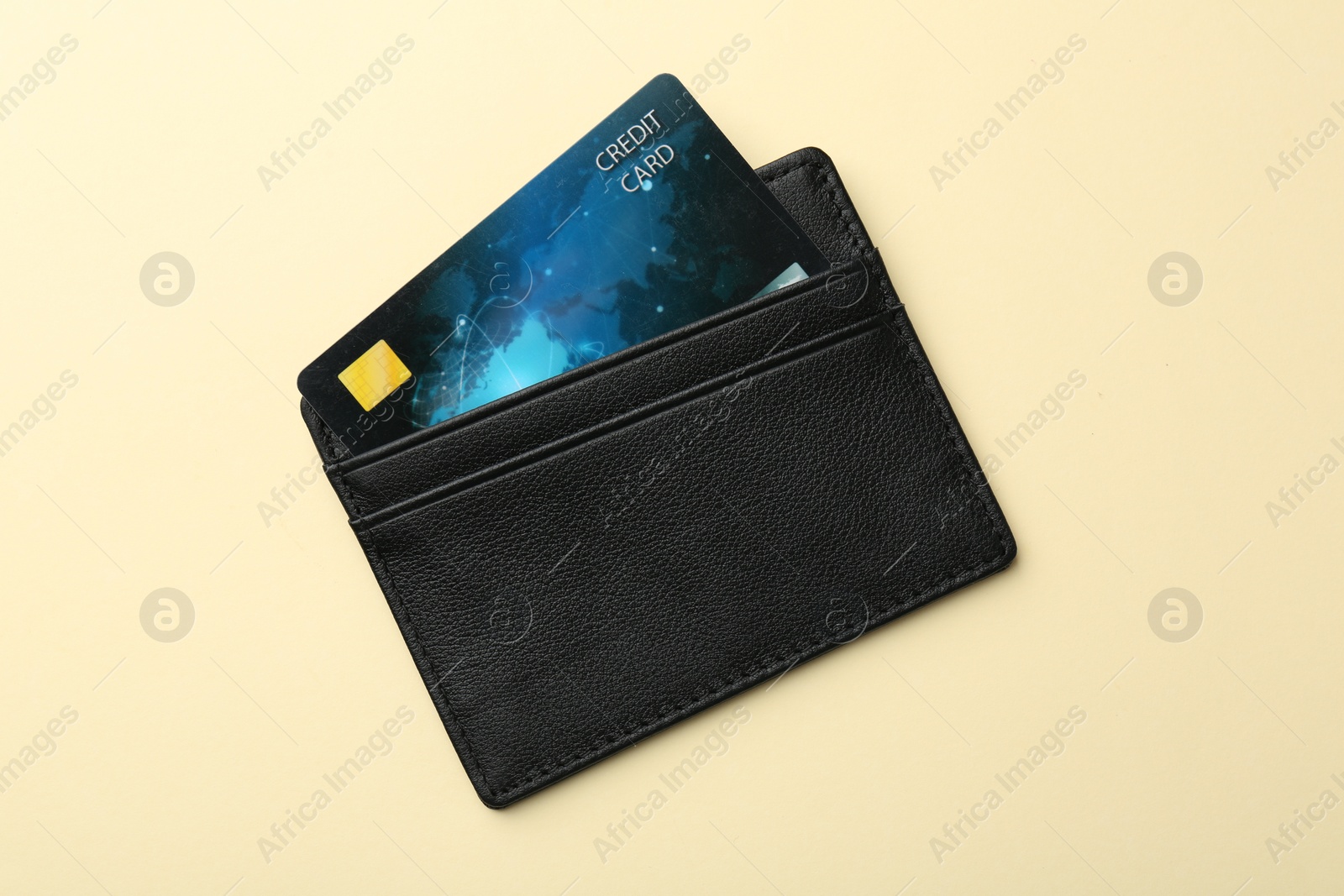 Photo of Leather card holder with credit card on beige background, top view