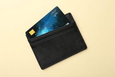 Photo of Leather card holder with credit card on beige background, top view