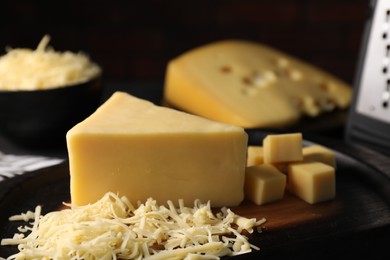 Photo of Grated and cut cheese on table, closeup