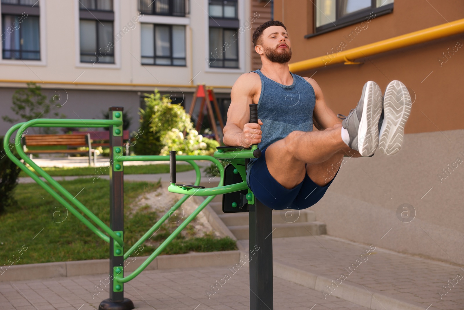 Photo of Man doing leg rise exercise at outdoor gym