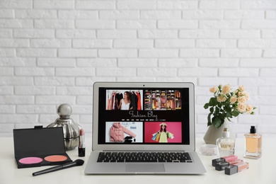 Laptop with open fashion blogger site on table