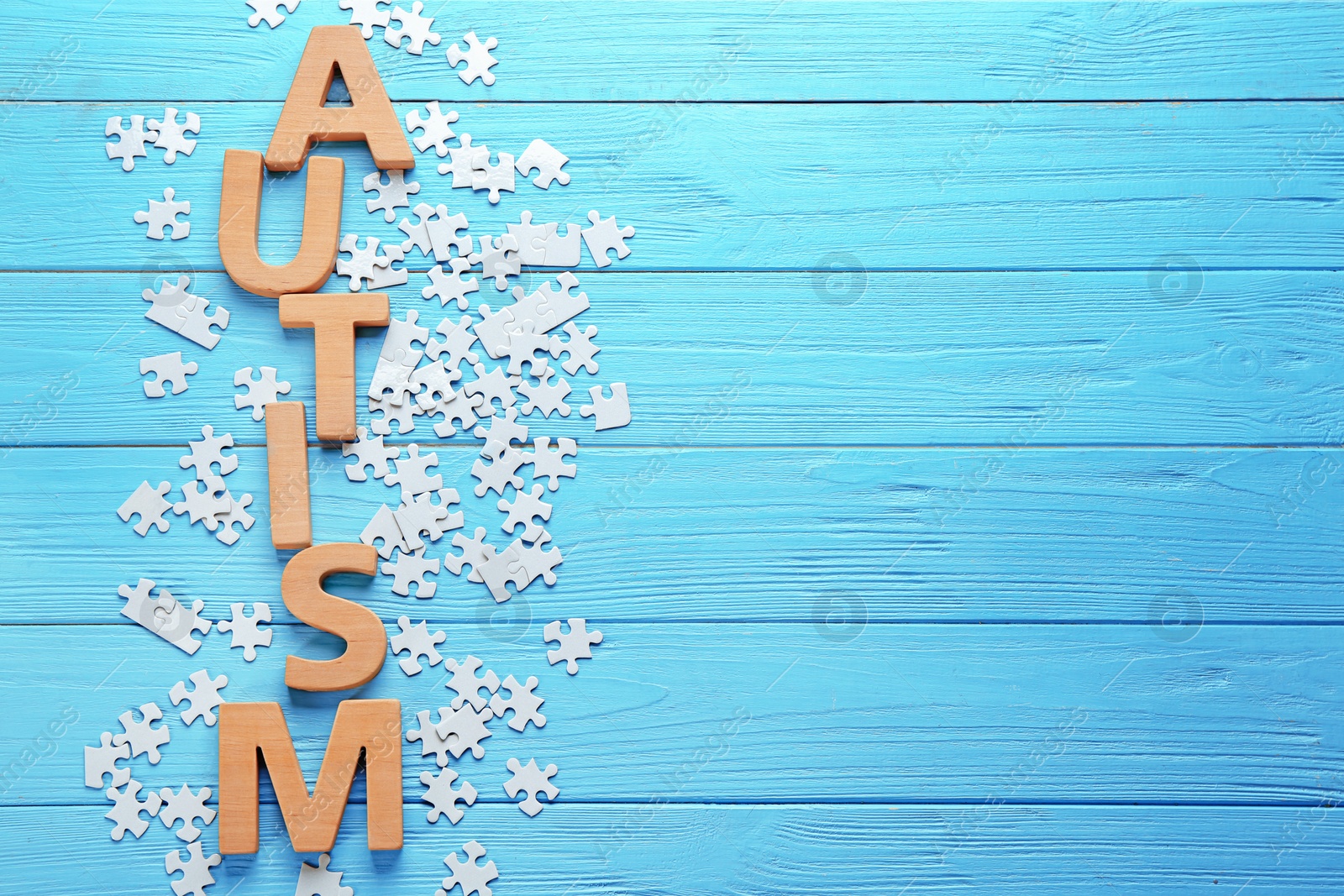 Photo of Word AUTISM made with letters with puzzles on wooden background
