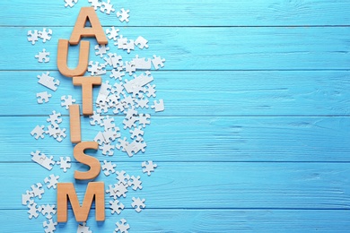 Word AUTISM made with letters with puzzles on wooden background