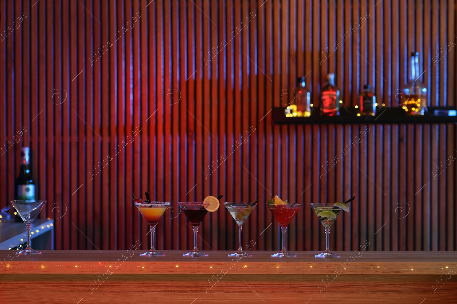 Photo of Different martini cocktails on table in bar, space for text