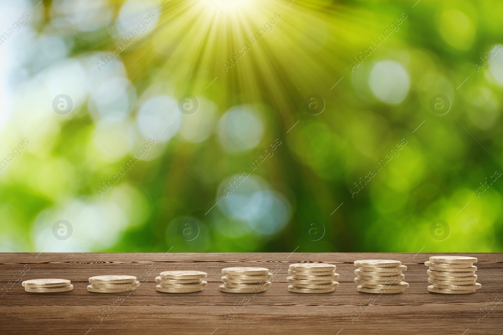 Image of Stacked coins on wooden table against blurred background. Investment concept