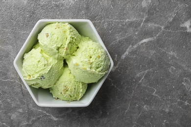 Delicious pistachio ice cream on grey marble table, top view. Space for text