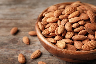 Tasty organic almond nuts in bowl on table