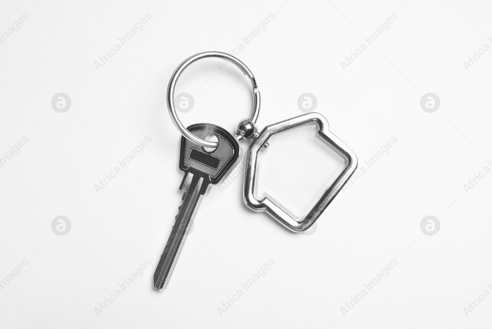 Photo of House key with trinket on white background, top view