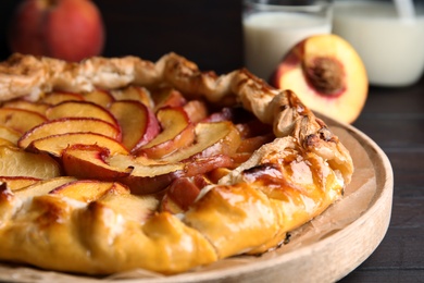 Photo of Delicious fresh peach pie on wooden table, closeup