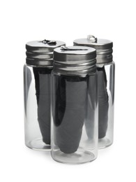 Photo of Rolls of natural organic dental floss in jars on white background