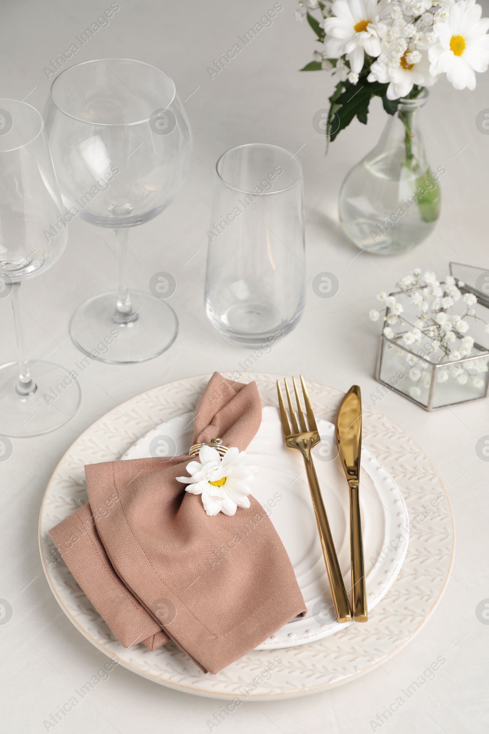 Photo of Elegant festive setting with floral decor on white table