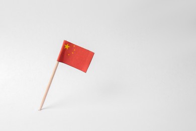 Photo of Small paper flag of China on light background. Space for text