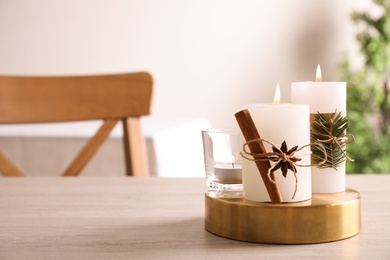 Photo of Decorated scented candles on table indoors, space for text