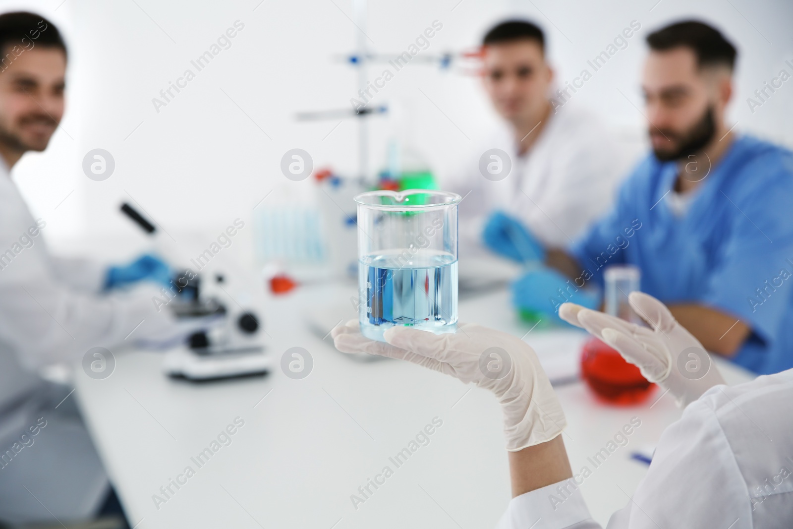 Photo of Medical student with beaker working in scientific laboratory