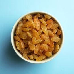 Photo of Bowl with raisins on color background, top view. Dried fruit as healthy snack