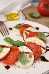 Delicious Caprese salad dressing with balsamic vinegar on plate, closeup