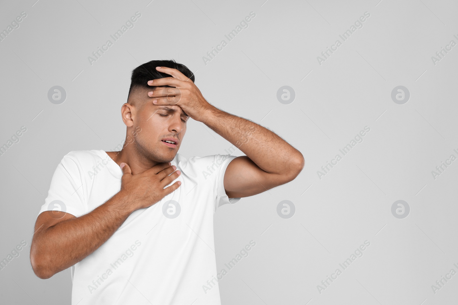 Photo of Man suffering from pain during breathing on grey background, space for text