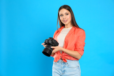 Photo of Professional photographer working on light blue background in studio. Space for text