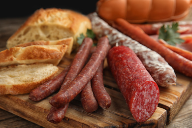 Photo of Different tasty sausages on wooden table, closeup