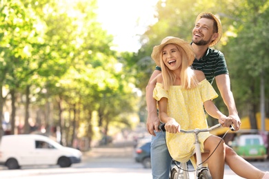 Photo of Happy couple riding bicycle together on street