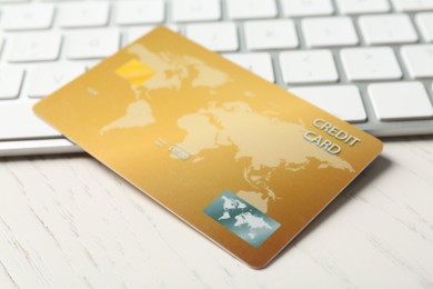 Photo of Online payment. Credit card and keyboard on white wooden table, closeup