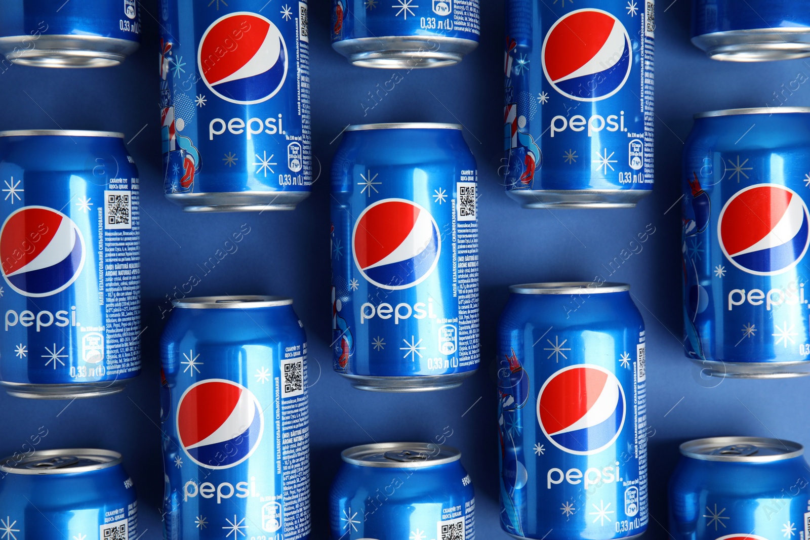 Photo of MYKOLAIV, UKRAINE - FEBRUARY 08, 2021: Cans of Pepsi on blue background, flat lay