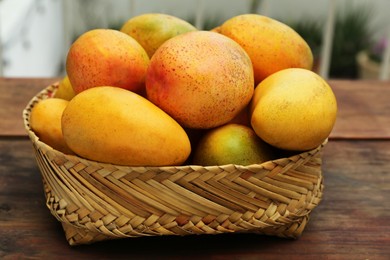 Photo of Delicious ripe juicy mangos on wooden table, closeup