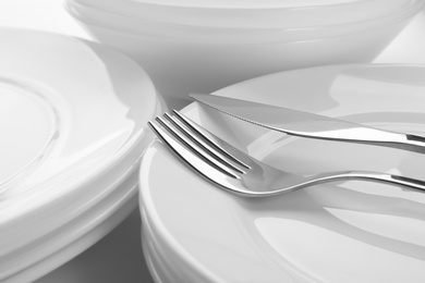 Photo of Many stacked plates with fork and knife, closeup