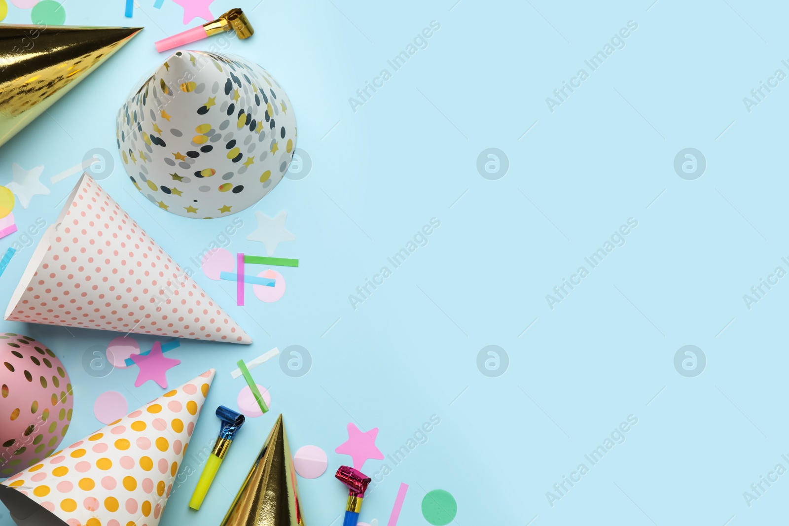 Photo of Flat lay composition with party hats and other festive items on light blue background. Space for text