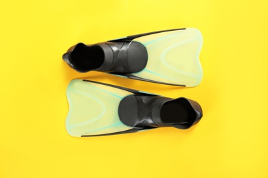 Photo of Swimming flippers on color background, top view