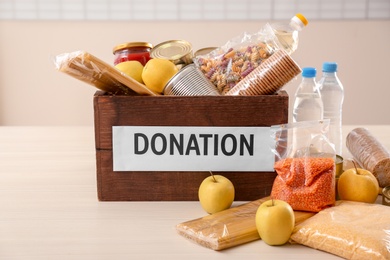 Photo of Donation box and different products on table indoors