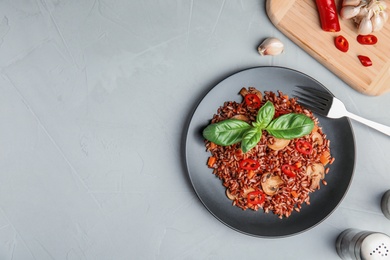 Photo of Plate of brown rice with vegetables served on table, flat lay. Space for text