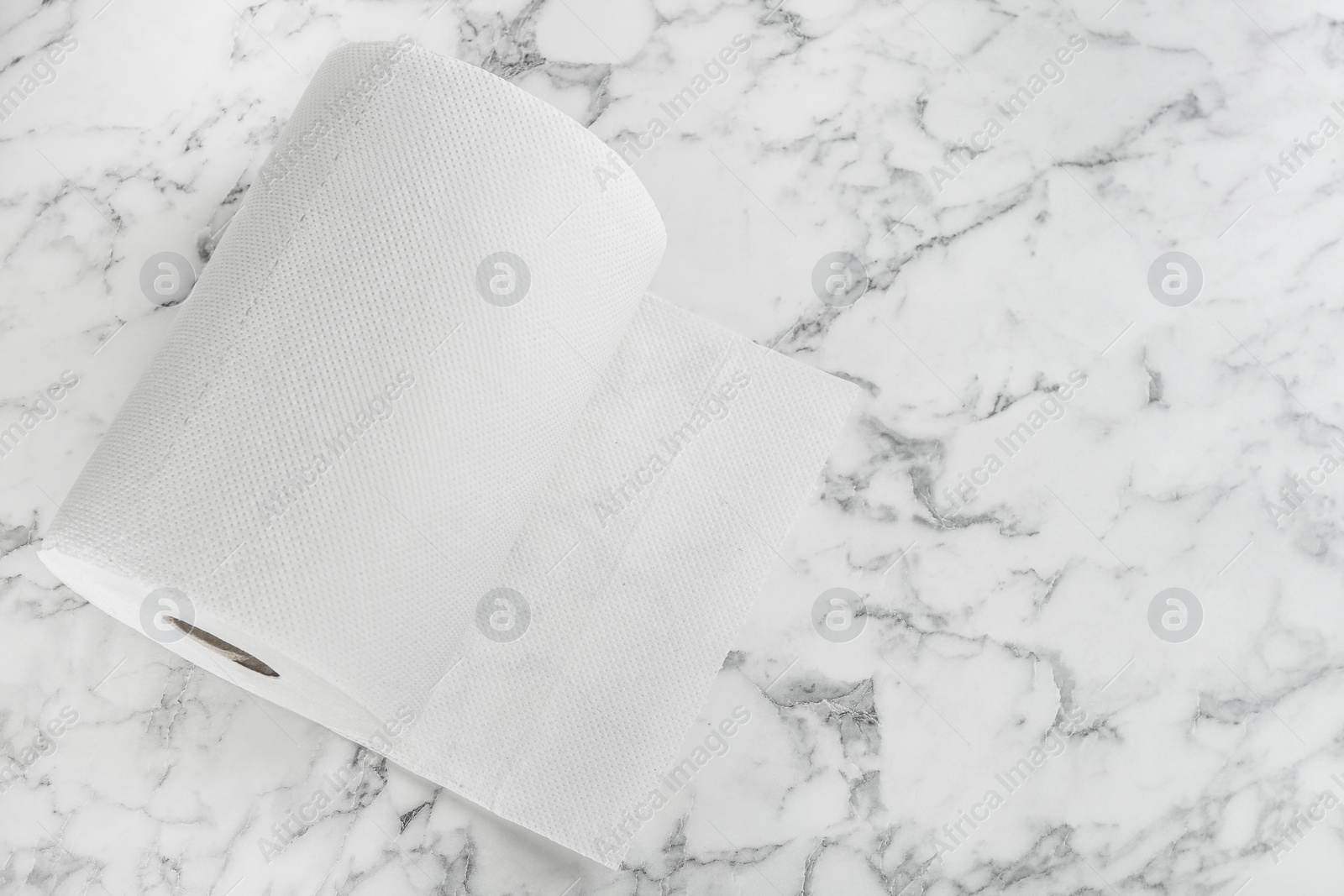 Photo of Roll of paper tissues on white marble table, top view. Space for text