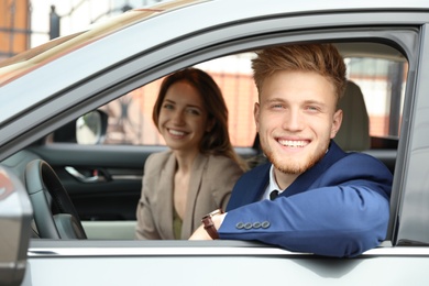 Photo of Happy young man and woman in modern car