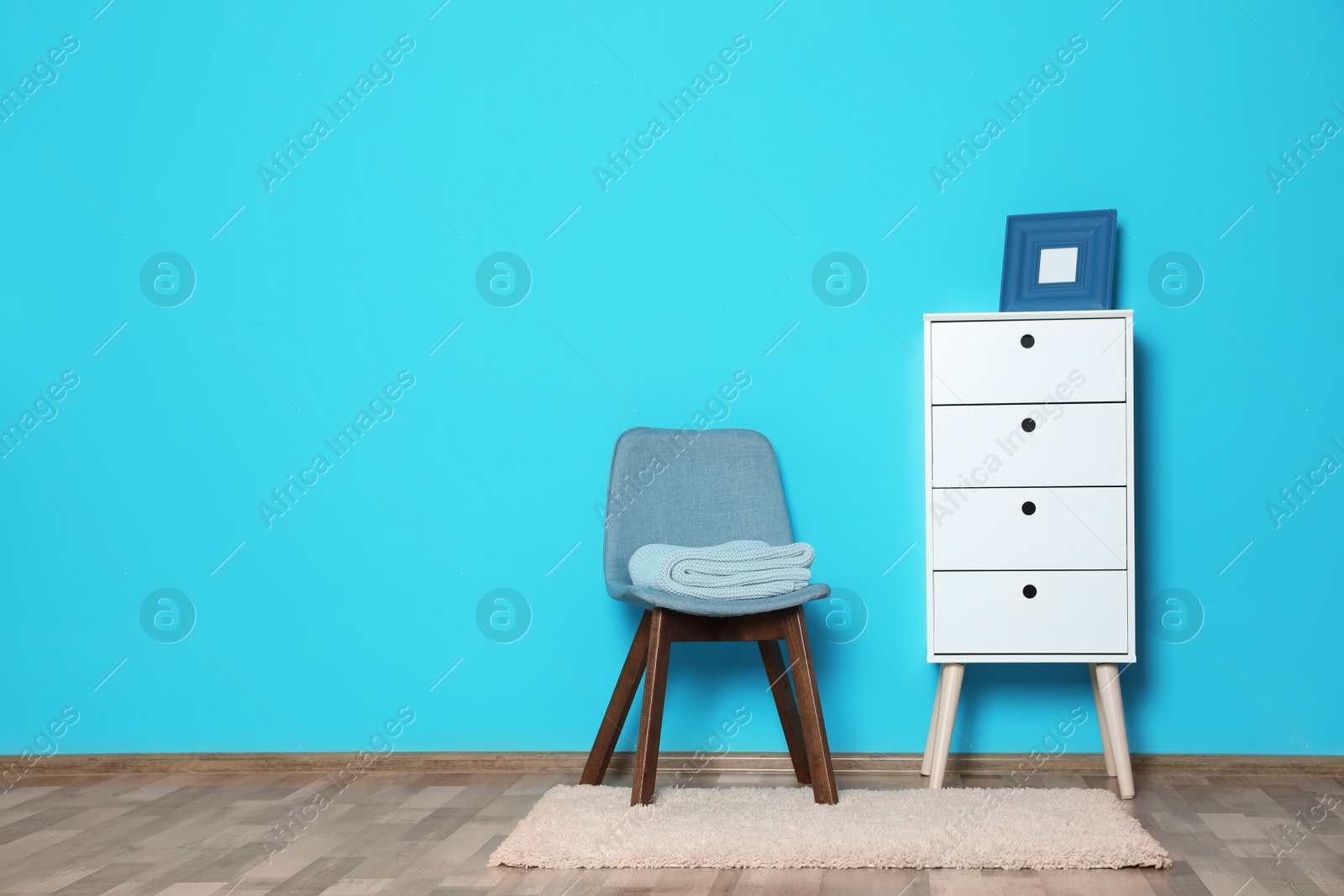 Photo of Stylish living room interior with chest of drawers and chair