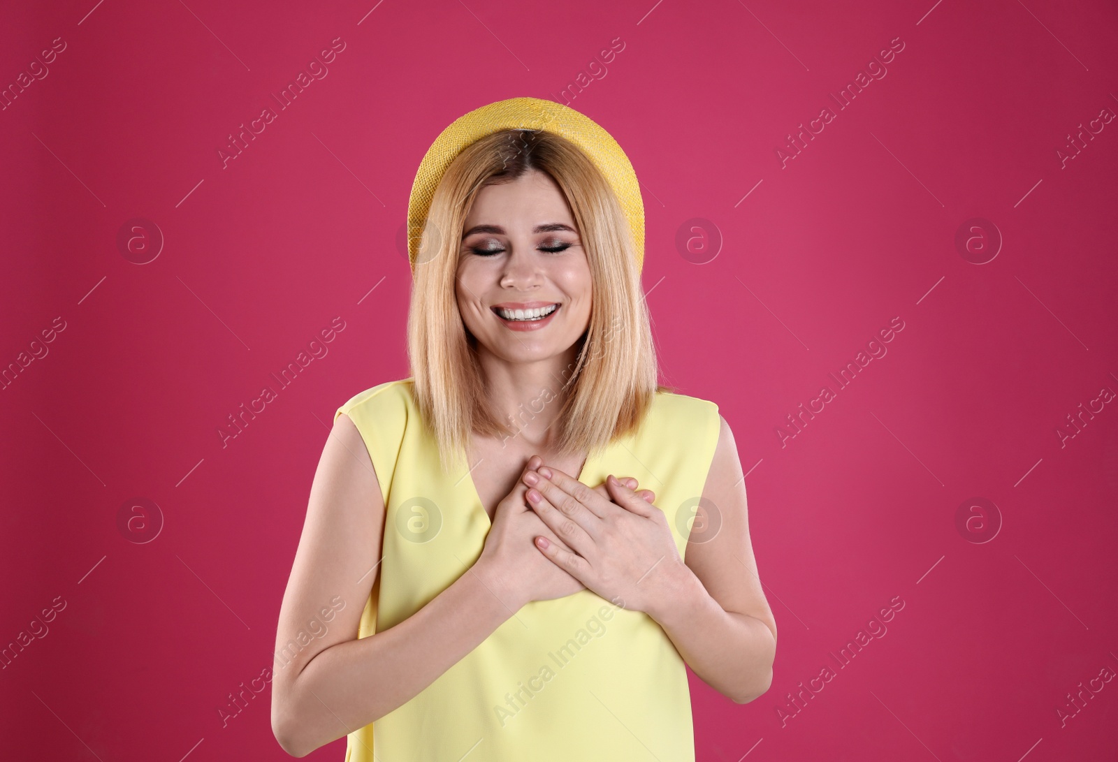 Photo of Portrait of woman holding hands near heart on color background