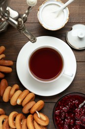 Photo of Flat lay composition with delicious ring shaped Sushki (dry bagels) and cup of tea on wooden table