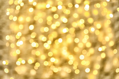 Blurred view of golden Christmas lights as background. Bokeh effect