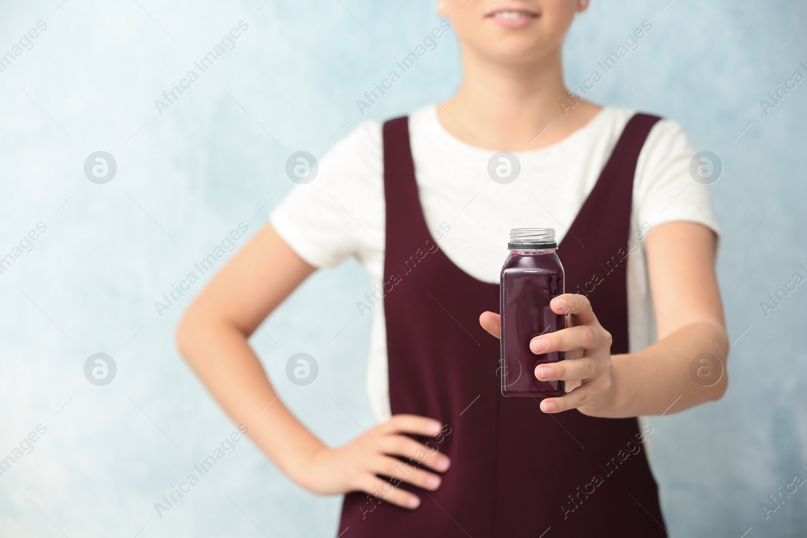 Photo of Woman with bottle of beet smoothie on light background, closeup