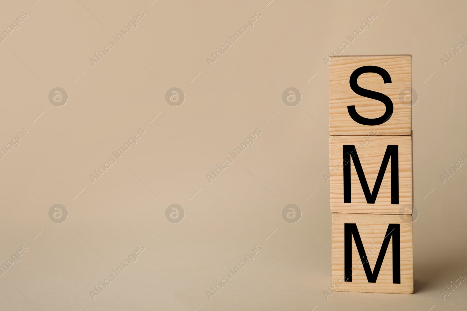 Photo of Wooden cubes with abbreviation SMM (Social media marketing) on beige background. Space for text