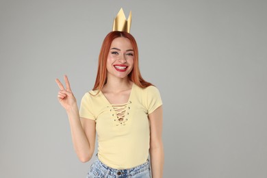 Photo of Beautiful young woman with princess crown on light grey background, space for text