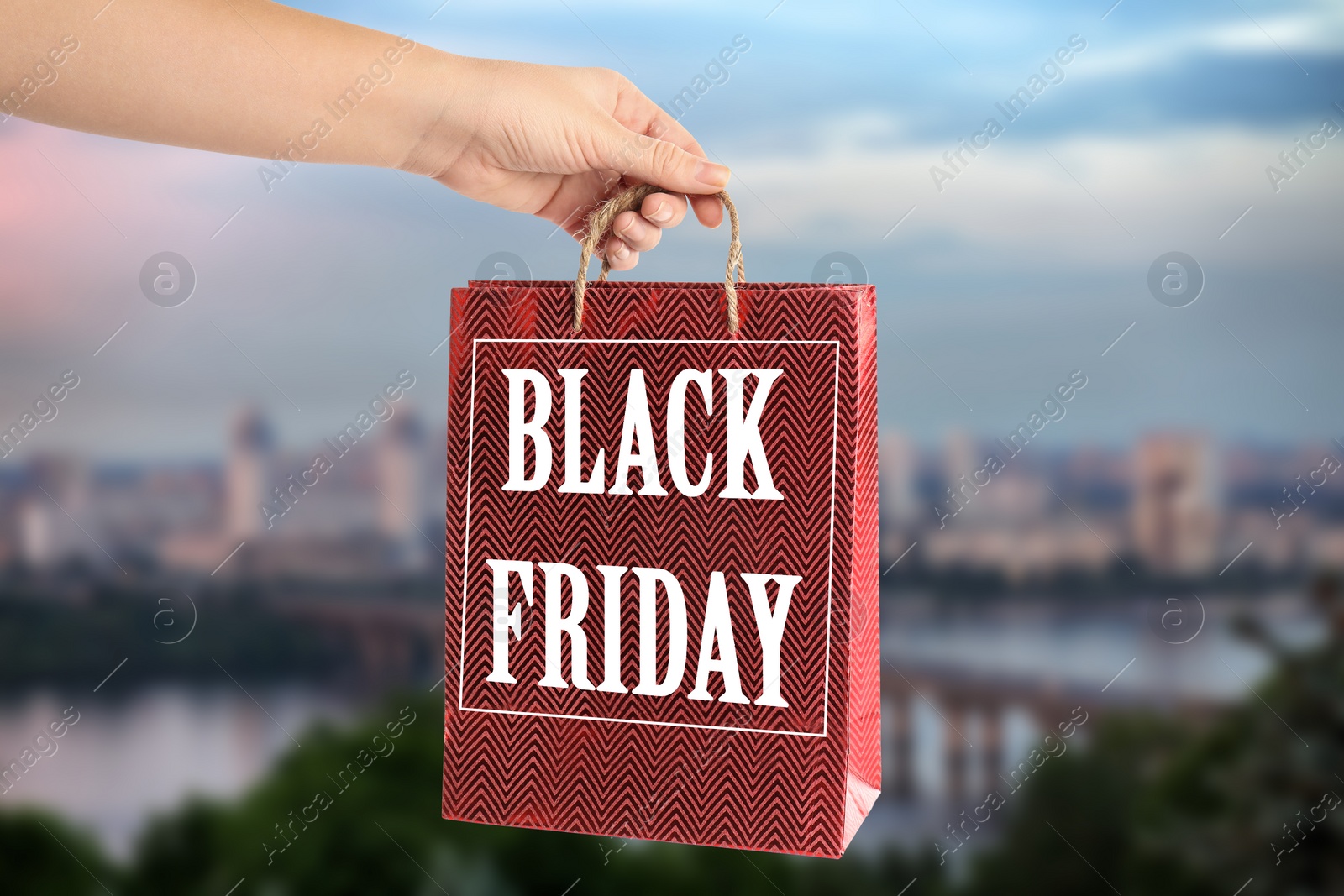 Image of Woman holding shopping bag with text BLACK FRIDAY outdoors, closeup