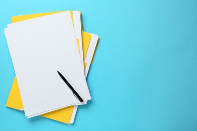 Photo of Yellow files with blank sheets of paper and pen on turquoise background, top view. Space for text