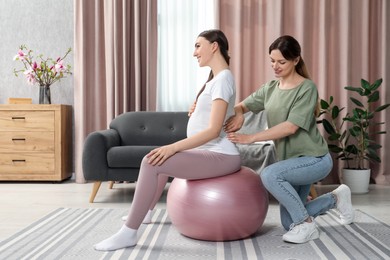 Photo of Doula massaging pregnant woman at home. Preparation for child birth