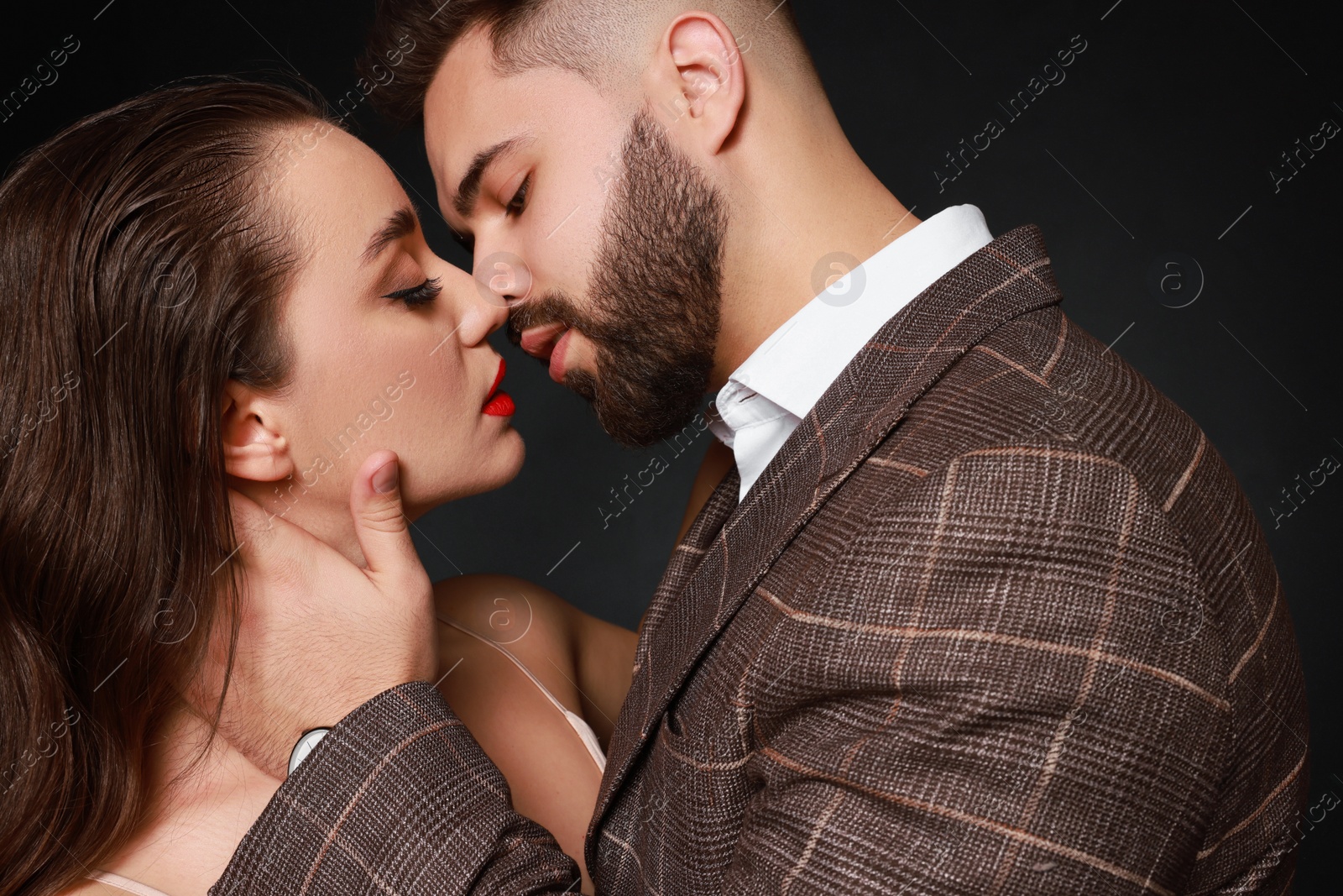 Photo of Handsome bearded man with sexy lady on dark background