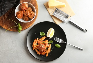 Photo of Delicious pasta with meatballs and tomato sauce on grey background