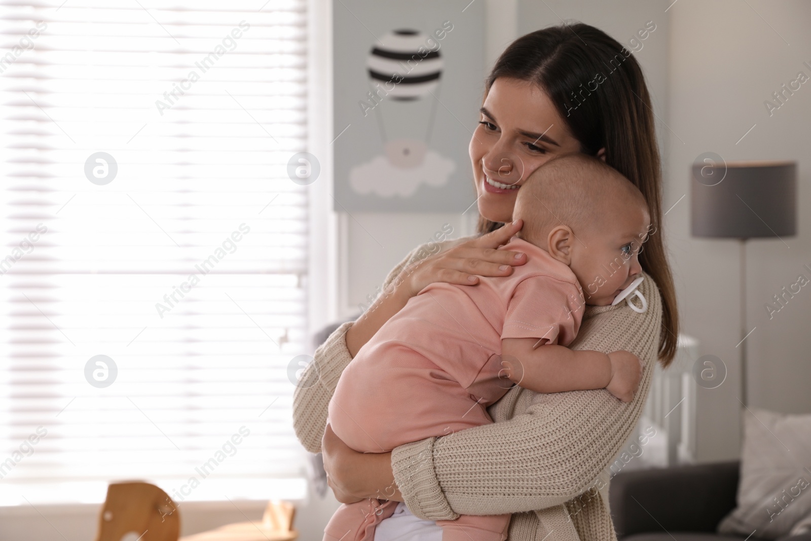 Photo of Young woman with her little baby at home