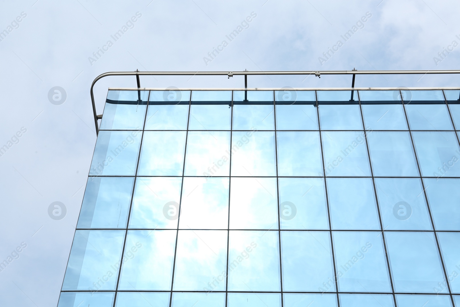 Photo of Modern building against blue sky, low angle view. Urban architecture