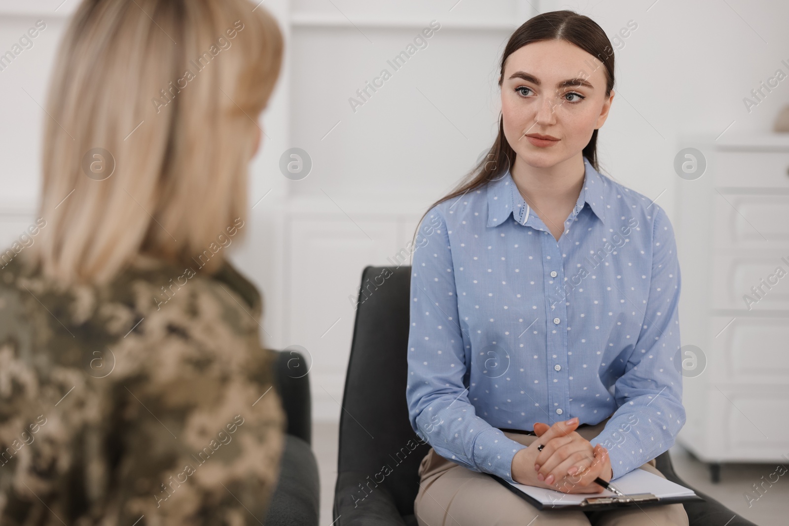 Photo of Psychotherapist working with military woman in office