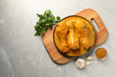 Tasty chicken curry and ingredients on grey textured table, flat lay. Space for text